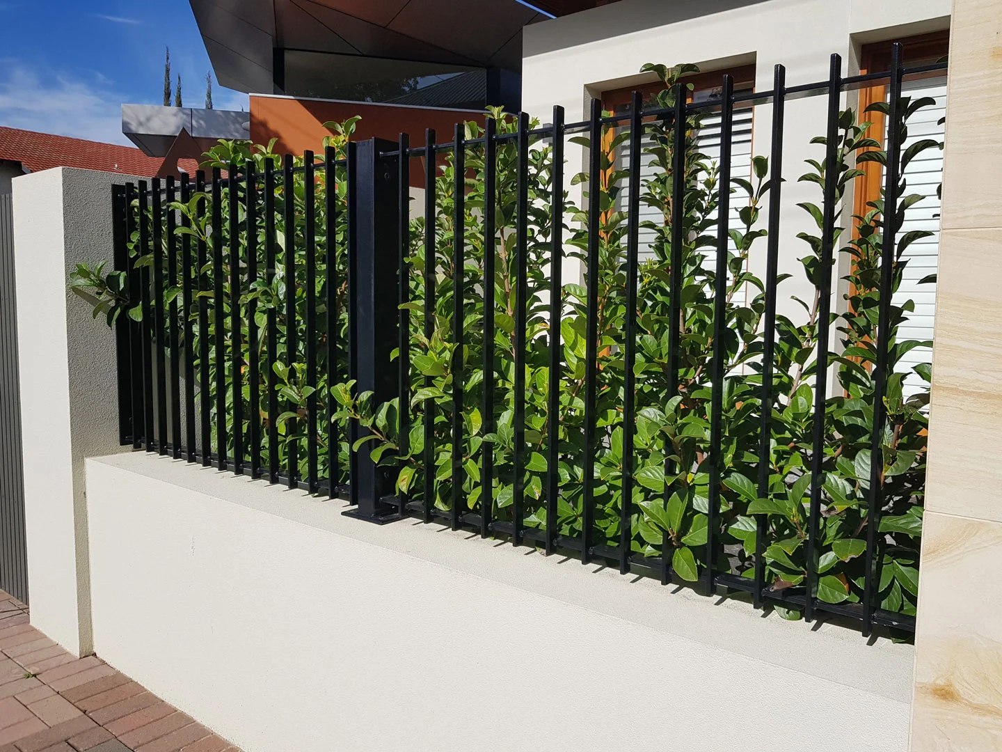 Black steel fence and gate enclosing a front garden