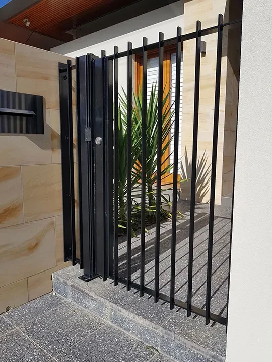 Custom black steel gate installed at a residential entrance