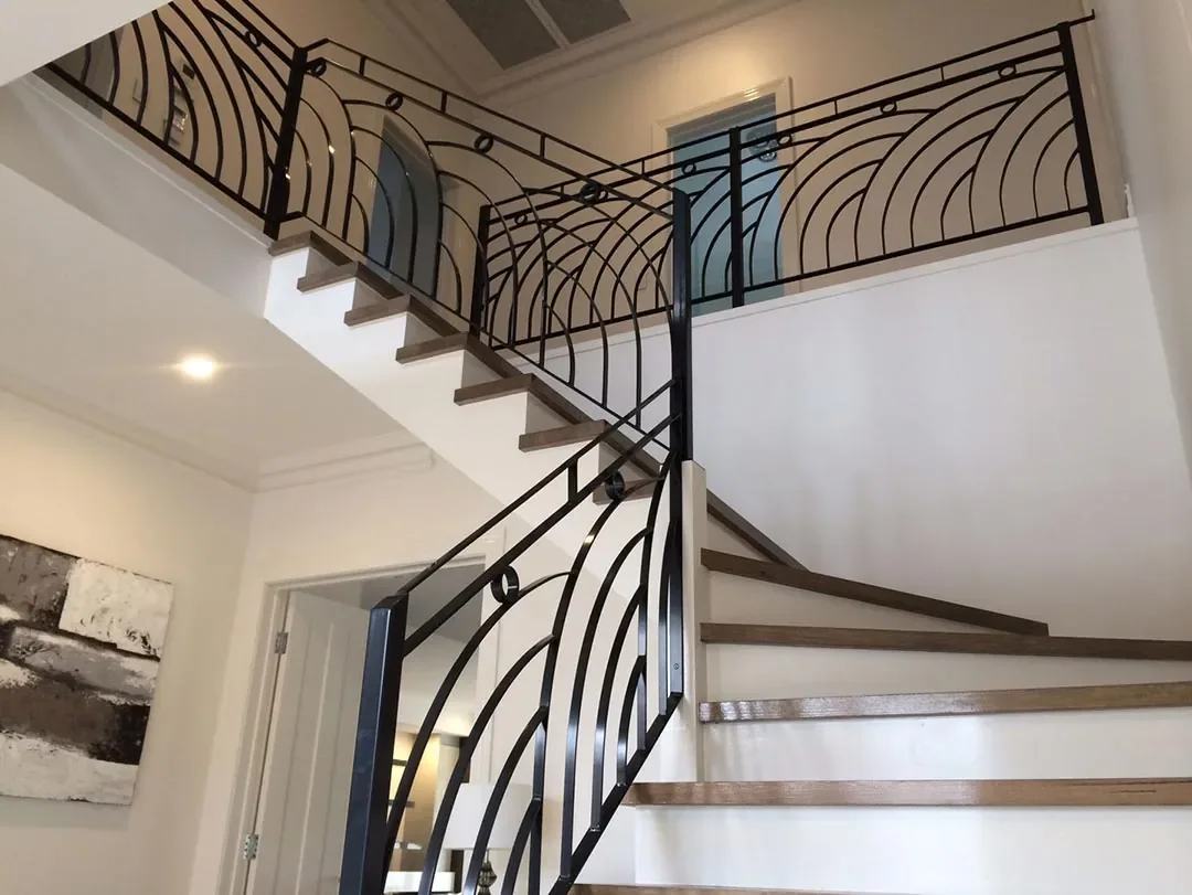 Custom curved wrought iron balustrade installed through a residential staircase