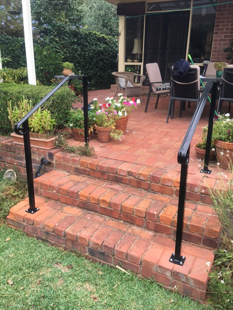 Exterior wrought iron handrails on brick garden steps